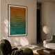 Elorium Dual Gradient Hand-Painted Wood Relief 3D Wall Art with orange-to-green pyramid grid, framed in black on a cream wall above a green armchair.