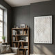 Elorium White Strata Hand-Painted Wood Relief 3D Wall Art by Giant Sculptures, framed on a grey living room wall beside a wooden bookshelf and window.
