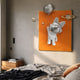 Chrome astronaut bunny holding a silver moon balloon on an orange panel with ringed planets, mounted above a bed beside a walnut nightstand.