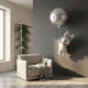 Chrome Astronaut Bunny Large Balloon 3D Wall Art by Giant Sculptures mounted on a grey wall above a beige armchair, with a silver moon balloon tethered above.