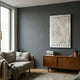 Elorium White Strata Hand-Painted Wood Relief 3D Wall Art by Giant Sculptures displayed on a dark grey wall above a mid-century teak sideboard in a living room.