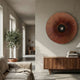Vanguard Mocha Bronze Leather 3D LED Wall Art by Giant Sculptures mounted on a beige wall above a walnut sideboard, beside an olive tree in a sunlit living room.