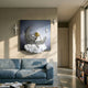 3D MoonSail Astronaut Swirl Wall Art by Giant Sculptures displayed above a blue sofa, with gold-helmeted astronaut rowing a crescent moon on a cloud beside star accents.