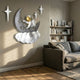 3D MoonSail Astronaut On Clouds Wall Art by Giant Sculptures mounted on a beige living room wall above a grey sofa, with white star accents beside the crescent moon scene.