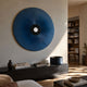 Vanguard Midnight Indigo Leather 3D LED Wall Art mounted above a dark sideboard in a sunlit living room, its blue sunburst circling a black central aperture.