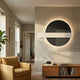 Aeon Slate Violet Leather 3D LED Wall Art by Giant Sculptures, a dark circle with white rectangle and lined panel glowing on a living room wall above an oak record console.