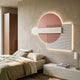 Aeon Petal Blush Leather 3D LED Wall Art by Giant Sculptures, blush pink circle with white rectangle and lined square, glowing above a linen bed.