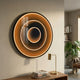 Reflex Gold Mirror 3D LED Wall Art by Giant Sculptures mounted above a wooden console with brass lamp and books, beside a bookshelf and monstera plant.