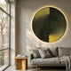 Astral Gold Crystal Porcelain LED Wall Art by Giant Sculptures, a circular black and gold geometric piece with backlit halo glow above a grey sofa by a window.