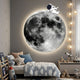 Cosmos Astronaut Drift UV Wood Carving LED Wall Art by Giant Sculptures, mounted in a kids' bedroom above a cloud-print bed, with rocket fairy lights alongside.