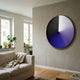Orbit Violet Hand-Painted Canvas 3D LED Wall Art by Giant Sculptures mounted on a beige wall above a linen sofa in a sunlit living room with plants.
