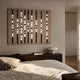 Strata Taupe LED Wall Art by Giant Sculptures mounted above a dark wood headboard in a modern bedroom, with nine illuminated black rods and a mushroom lamp nearby.