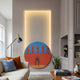 Orion Crimson Silhouettes Oil Painting LED Wall Art by Giant Sculptures, circular piece with red balloons and seated figure, LED halo glow, above a beige sofa.