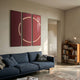 Helios Ruby Crystal Porcelain LED Wall Art by Giant Sculptures, a glossy red three-panel triptych with a glowing white LED circle, above a navy sofa.