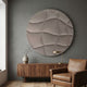 Orbura Ivory Circular 3D Wood Relief Wall Art by Giant Sculptures mounted on a grey wall above a walnut sideboard with vase, brass lamp, and leather armchair.