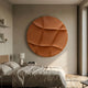 Giant Sculptures Orbura Terracotta Circular 3D Wood Relief Wall Art mounted above a nightstand in a neutral bedroom with linen bedding and a wooden bedframe.