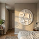 Giant Sculptures Orbura White Circular 3D Wood Relief Wall Art mounted on a beige bedroom wall beside a fiddle-leaf fig, wooden stool, and linen-dressed bed.