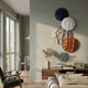 Orbura 5-Set Circular Terra & Ivory 3D Wood Relief Wall Art by Giant Sculptures displayed vertically on a sage wall above a walnut console in a modern living room.