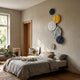Orbura 6-Set Circular 3D Wood Relief Wall Art by Giant Sculptures in navy, yellow, white, grey, and beige, displayed above a linen-dressed bed.