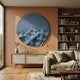 Solivis Midnight Blue Round 3D Wood Relief Wall Art by Giant Sculptures mounted on a terracotta wall above a wooden sideboard beside a linen sofa and bookshelves.