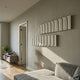 Vireus White Long Dual Panel 3D Wood Relief Wall Art by Giant Sculptures, two ribbed pale panels mounted on a beige living room wall near a doorway.