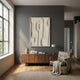 Terravura Rectangular Sandstone I 3D Wood Relief Wall Art in sandstone-beige hangs on a grey wall above a walnut sideboard with vase, books and leather chair.