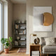 Solvara Gold & White Wood Relief 3D Wall Art by Giant Sculptures displayed on a beige wall in a modern living room with bookshelf, brass lamp, and sofa.