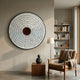 Solis Radiant Deep Red Core Wood Relief 3D Wall Art by Giant Sculptures mounted above a leather armchair, side table, and bookshelf in a modern reading nook.