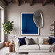Reflectra Deep Blue Wood Relief 3D Wall Art with silver mirror overlapping its upper right corner, hung above a white sofa in a modern living room.