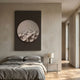 Solivis Arctic 3D Wood Relief Wall Art by Giant Sculptures, a pale carved circular disc on a dark rectangular panel, displayed above a grey linen bed in a minimalist bedroom.