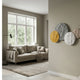 Orbita 4-Set Circular 3D Wood Relief Wall Art by Giant Sculptures in gold, grey, white, and beige, displayed on a beige wall beside a living room with a taupe sofa.