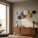 Orbita 6-Set Circular Neutral Grey 3D Wood Relief Wall Art by Giant Sculptures arranged above a walnut sideboard with brass lamp in a sunlit living room.