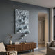 Fluxion Soft Blue 3D Wood Relief Wall Art with metal balls mounted above a walnut sideboard in a grey-toned living room with armchair and vase.