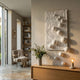 Fluxion White 3D Wood Relief Wall Art With Metal Ball by Giant Sculptures displayed in a Nordic living room above an oak console with armchair and bookshelves.