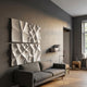 Tessara 4-Panel Set White 3D Wood Relief Wall Art by Giant Sculptures mounted above a grey sofa in a modern living room with dark walls and oak flooring.
