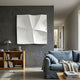 Tessara I White 3D Wood Relief Wall Art by Giant Sculptures displayed on a dark grey feature wall above a wooden bookcase beside a blue linen sofa.