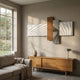 Axentra Brown & White Geometric Wood Relief 3D Wall Art by Giant Sculptures displayed above a wooden sideboard in a sunlit living room with grey sofa.