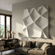 Tessara II White 3D Wood Relief Wall Art by Giant Sculptures, a large carved geometric panel mounted above a grey sofa in a sunlit living room with bookshelf.
