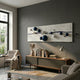 Lustra Sapphire Blue & White 3D Wood Relief Wall Art mounted on a grey wall above a wooden sideboard with books, beside an armchair and bright window.