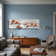 Lustra Orange & White 3D Wood Relief Wall Art by Giant Sculptures mounted above a teak sideboard in a blue-walled living room with grey sofa and armchair.