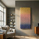 Spectrum Weave Vertical Sunset Hues Wood Relief 3D Wall Art by Giant Sculptures, yellow to pink to blue gradient, mounted on a grey living room wall beside a bookshelf.