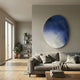 Giant Sculptures Fluctus Blue Textured Sandstone Wood Relief 3D Wall Art mounted above a grey sofa in a Nordic living room with bookshelf and plants.