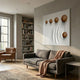 Galactica White Wood Relief 3D Wall Art by Giant Sculptures displayed above a grey sofa in a Nordic living room with leather armchair and bookshelf.