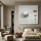 Galactica White Wood Relief 3D Wall Art with white metal spheres displayed above a bed in a neutral bedroom with armchair, ottoman, and wooden nightstand.