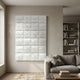 Vellura White Textured Wood Relief 3D Wall Art by Giant Sculptures, a grid of carved white tiles displayed above a grey sofa beside a bookshelf.