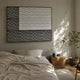 Trelume White & Grey Wavy Wood Relief 3D Wall Art by Giant Sculptures mounted above a linen-dressed bed with a wooden nightstand, globe lamp, and potted tree.