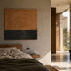 Artura Honey & Black Square Hand-Painted 3D Relief Wall Art with concentric ridges mounted above a wooden bed in a sunlit wabi-sabi bedroom.