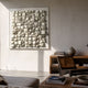 Exalta Wood Relief 3D Wall Art In Acrylic Box by Giant Sculptures displayed above a wooden console with books, a vase, and a cane chair in a neutral living room.