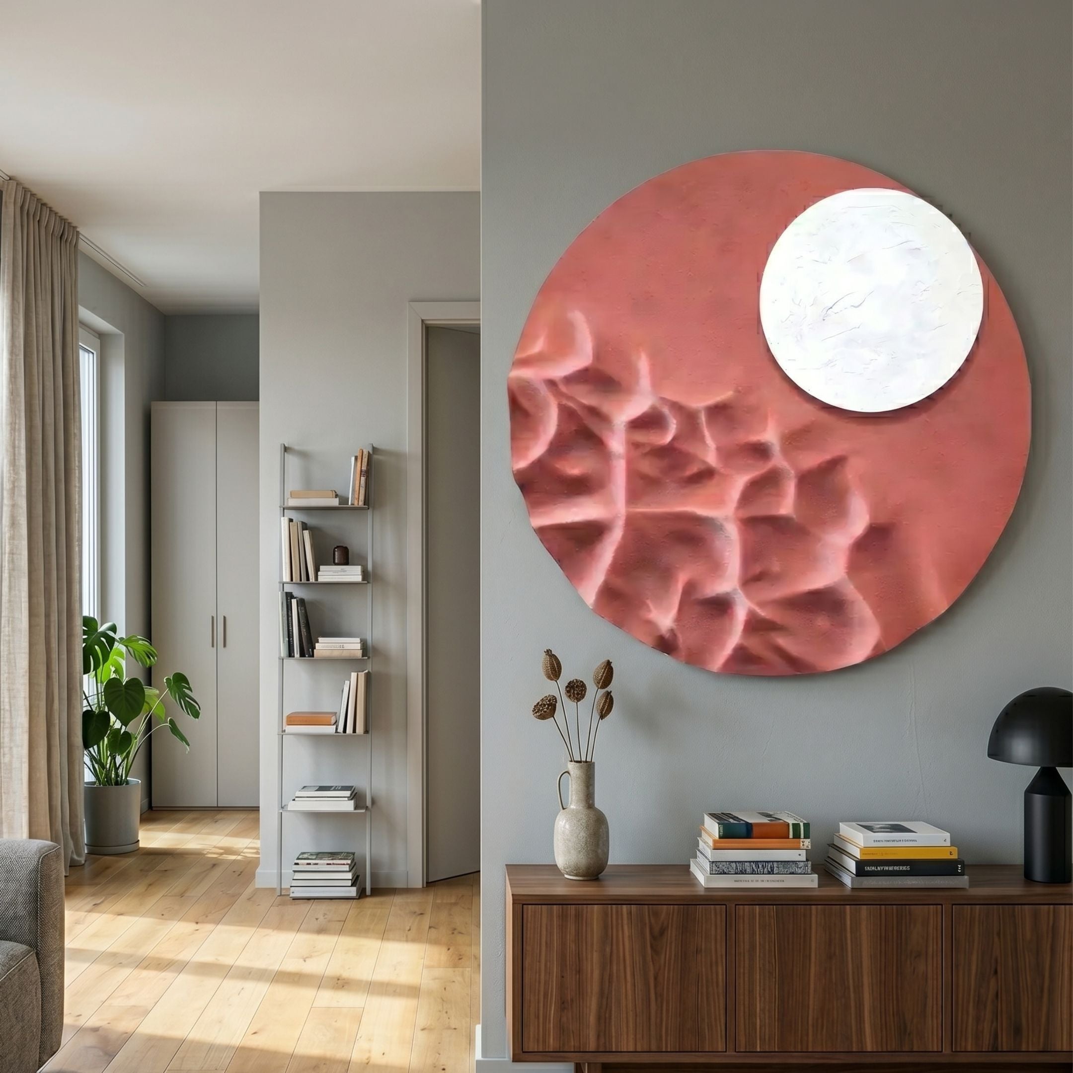 Verve Dusty Rose Wood Relief 3D Wall Art by Giant Sculptures, a circular carved piece with ridged pink field and smooth white moon disc above a walnut sideboard.