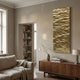 Illume Gold IV Hand-Painted Wood Relief 3D Wall Art by Giant Sculptures, a tall rippled gold panel mounted above a walnut sideboard in a neutral living room.
